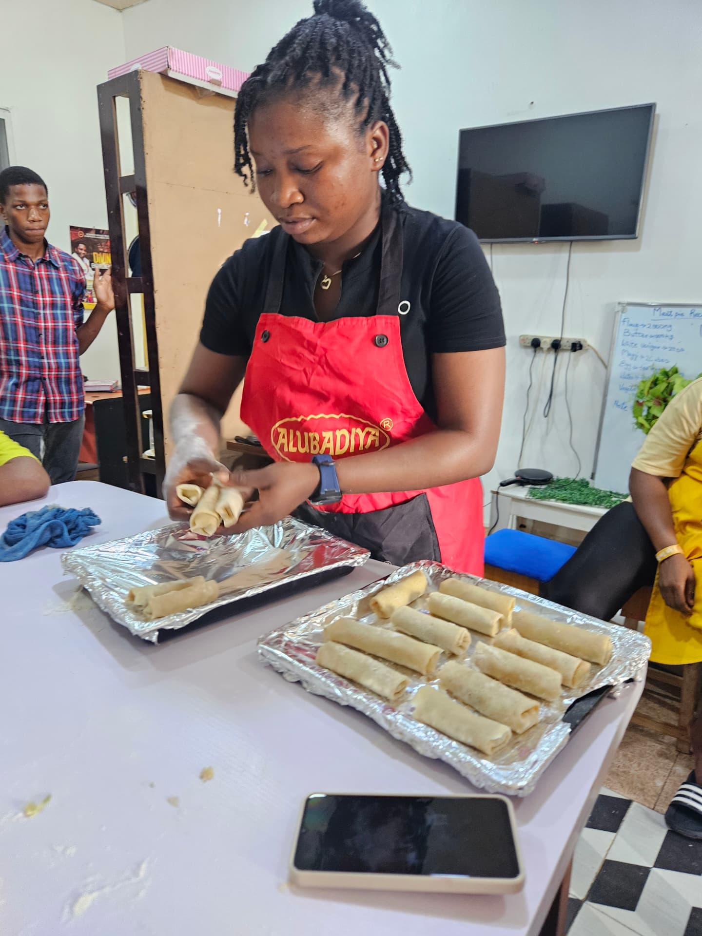 Student preparing spring rolls during a practical class