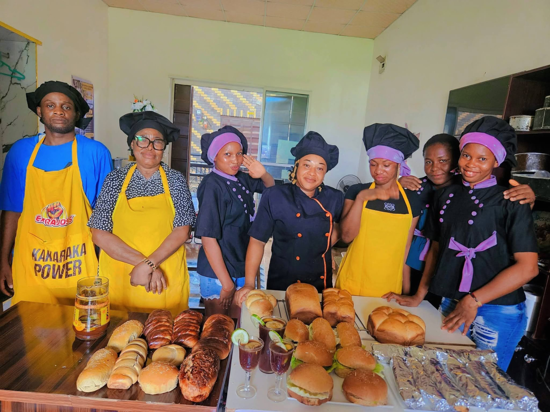 Team displaying freshly baked bread, burgers and drinks